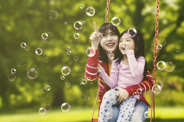 Mulher e criança tocando bolhas — Fotografia de Stock