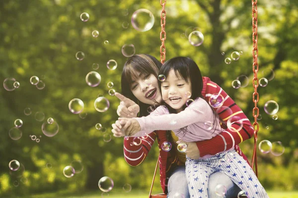 Bonita madre e hijo tocando burbujas —  Fotos de Stock