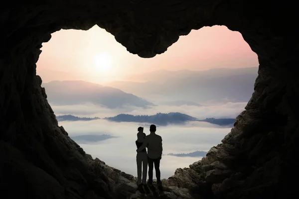 Familia feliz dentro de la cueva en forma de símbolo del corazón —  Fotos de Stock