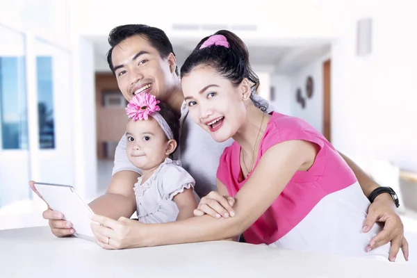 Gelukkige ouders en kind met behulp van digitale tablet — Stockfoto