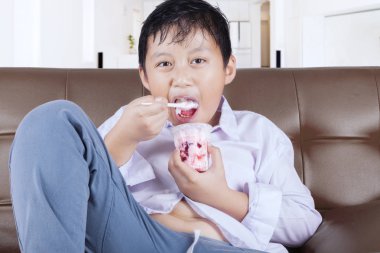 Çocuk oturma odasında dondurma yiyor