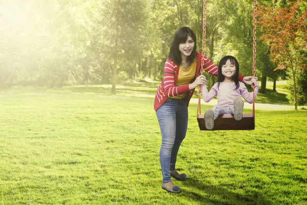 Mãe alegre e criança brincando swing — Fotografia de Stock