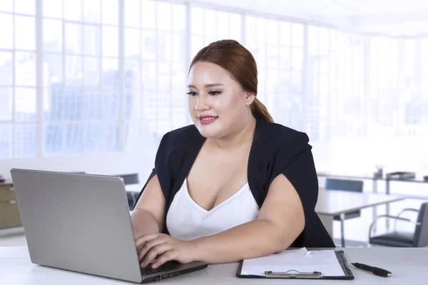 Mujer de negocios escribiendo en el ordenador portátil en la oficina —  Fotos de Stock
