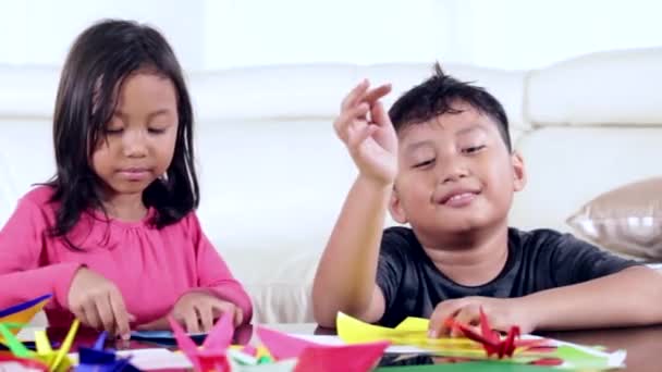 Två barn leker origamipapper — Stockvideo