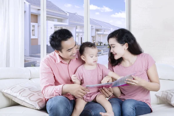 Aziatische ouders en dochter lezen van een boek — Stockfoto