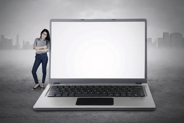 Предприниматель стоит с большим ноутбуком — стоковое фото