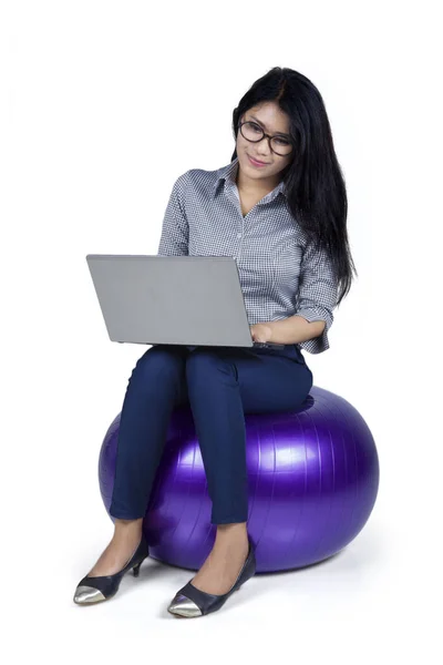 Vrouwelijke ondernemer zit op de bal met laptop — Stockfoto