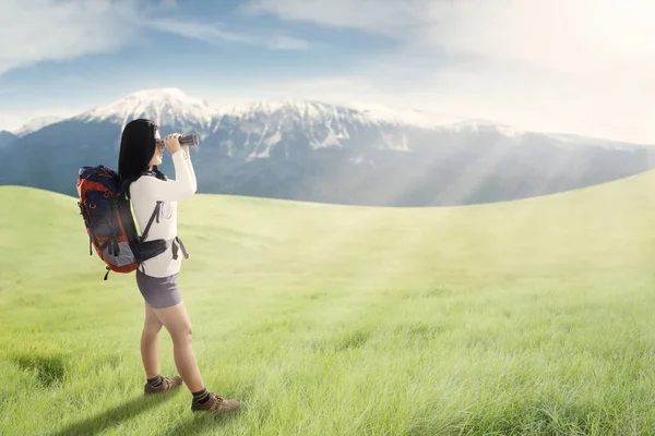 女性的徒步旅行者在草原上使用双筒望远镜 — 图库照片