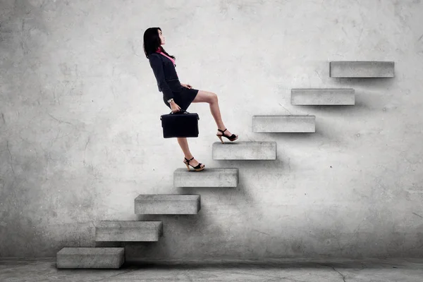 Kvinnlig arbetstagare bär portföljen på trappor — Stockfoto