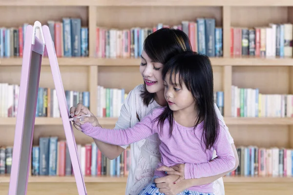 Ragazza impara a scrivere con il gesso — Foto Stock