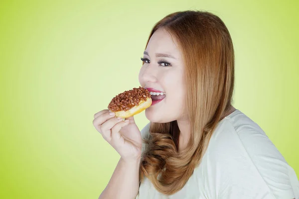 Mulher feliz come donut — Fotografia de Stock