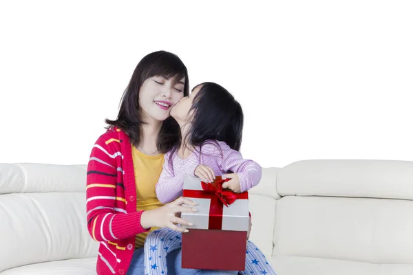 Niña besa a su madre con un regalo — Foto de Stock