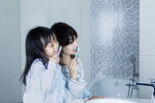 Мати і дитина чистять зуби разом — стокове фото
