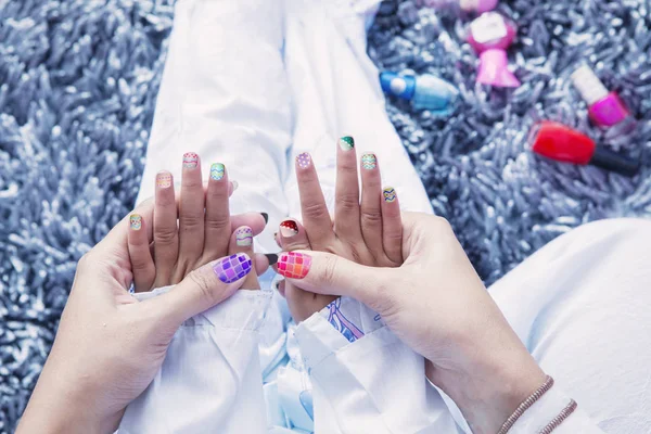 Esmalte de uñas multicolor en el dedo — Foto de Stock