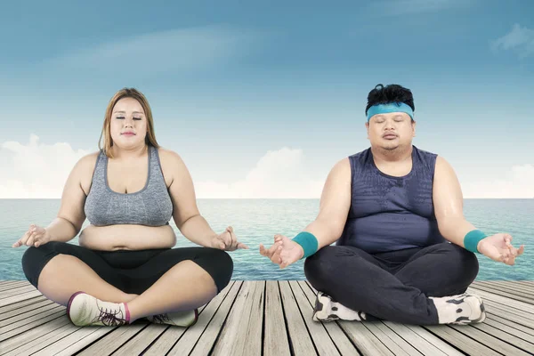 Kilolu insanlar iskele üzerinde meditasyon — Stok fotoğraf