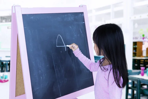 Student schrijven op een schoolbord in de klas — Stockfoto