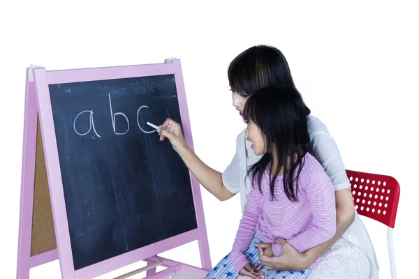 Woman teaches alphabet to her daughter