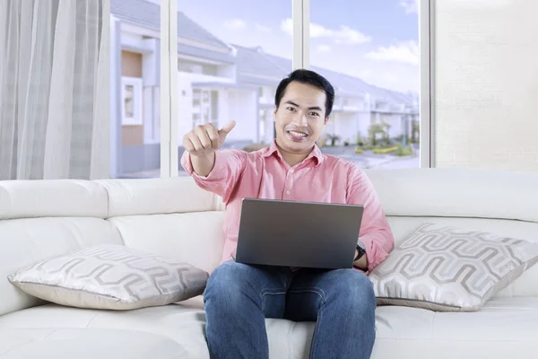 Young Asian person with laptop on couch — Stock Photo, Image