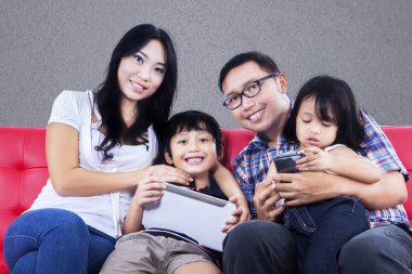 Kırmızı koltuk, gri arka plan üzerinde mutlu aile