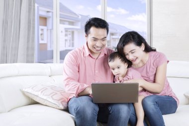 Ailesi kızlarının ile bir dizüstü bilgisayar kullanarak