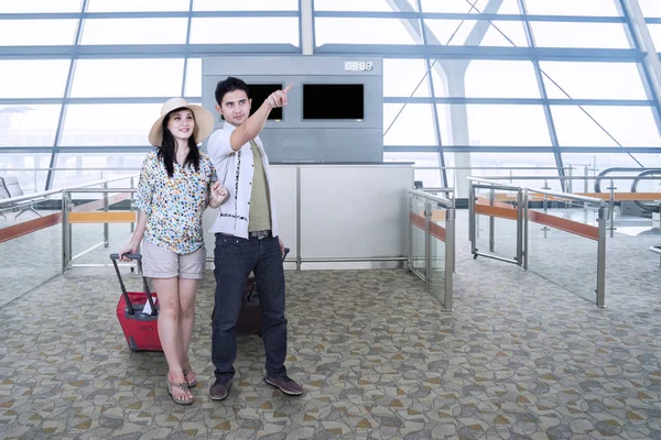 Paar schaut sich am Flughafen etwas an — Stockfoto