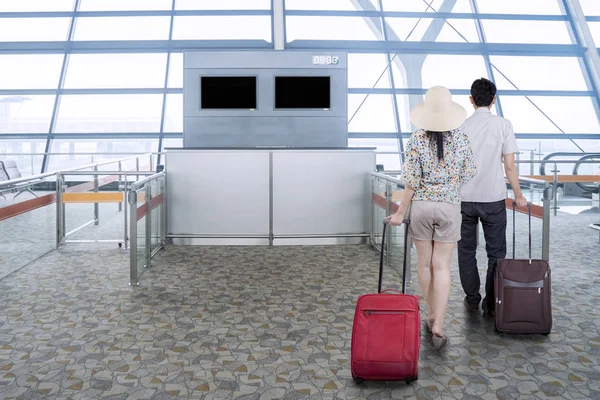 Ζευγάρι με τις τσάντες με τα πόδια στο αεροδρόμιο — Φωτογραφία Αρχείου
