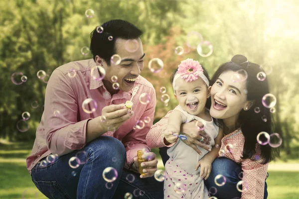 Famiglia che gioca con le bolle nel parco — Foto Stock