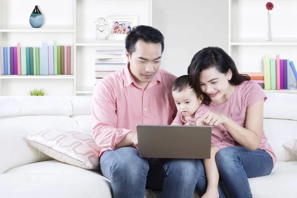 Familj med en bärbar dator i vardagsrummet — Stockfoto