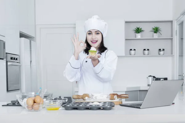Chef feminino com cupcake mostra sinal OK — Fotografia de Stock