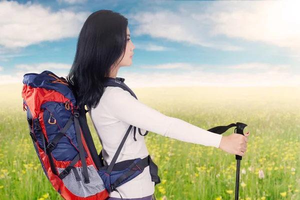 Female hiker enjoys blossom flowers in meadow — Stock Photo, Image