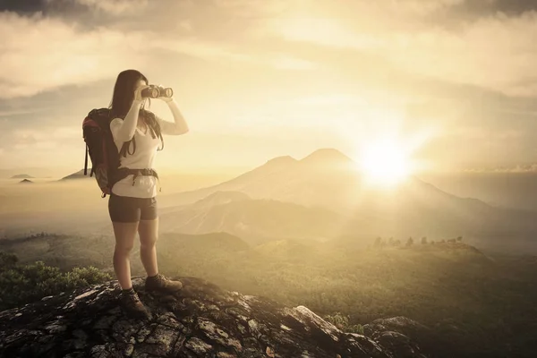 Turista donna con binocolo nella scogliera — Foto Stock