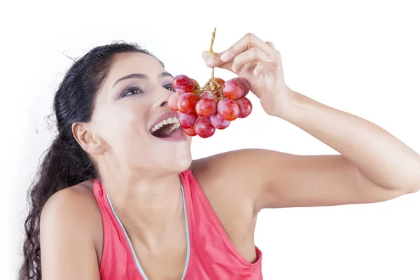 Femme indienne dégustation de raisin en studio — Photo