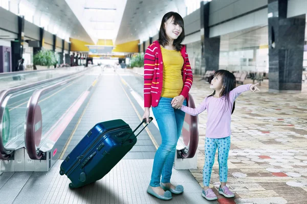 Mãe e filha levando mala no aeroporto — Fotografia de Stock