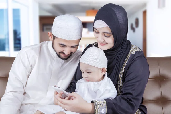 Muslimští rodiče a dítě pomocí mobilní telefon — Stock fotografie