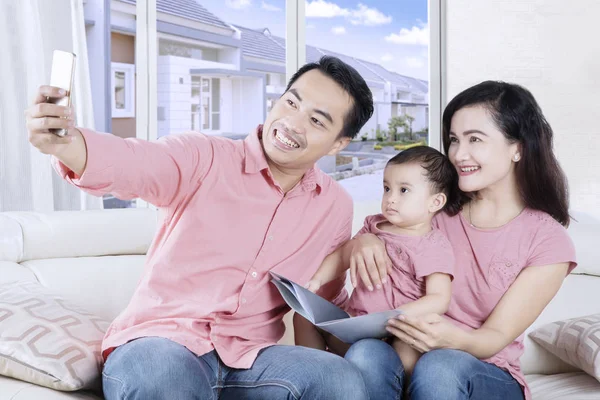 Усміхнена сім'я фотографує себе вдома — стокове фото