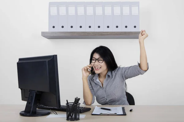 Mulher de sucesso com smartphone no local de trabalho — Fotografia de Stock