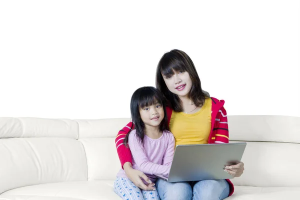 女人和她的孩子坐在沙发上的笔记本电脑 — 图库照片