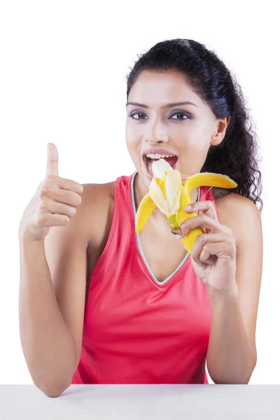 Vrouw eet banaan op studio — Stockfoto