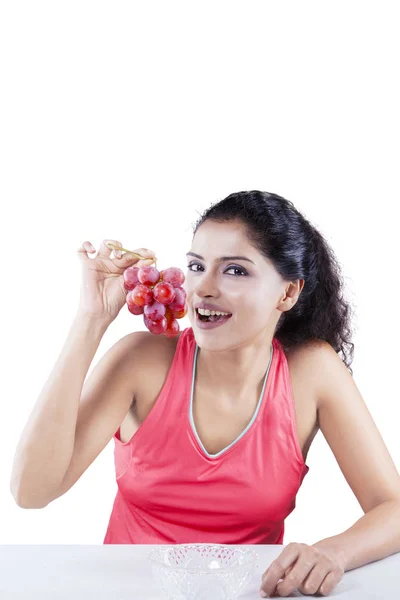 Mujer joven sosteniendo racimo de uvas en el estudio — Foto de Stock