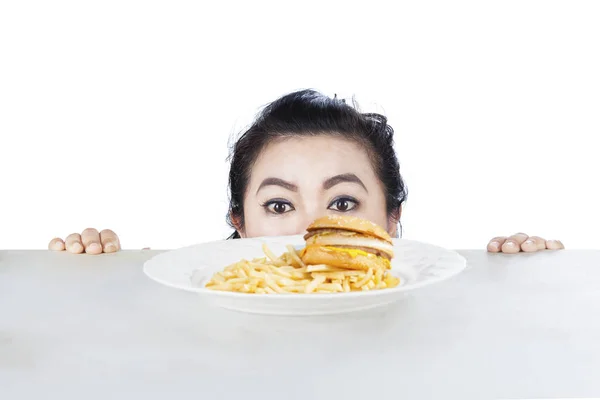 Kadın gözetleme hamburger bir plaka üzerinde — Stok fotoğraf