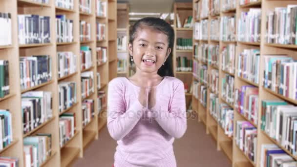 Female student clapping hands in library — Stock Video
