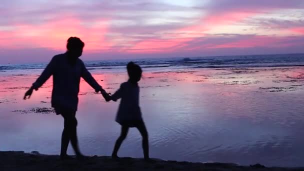 Silhouette Happy Mother Her Daughter Walking Beach While Holding Hands — Stock Video