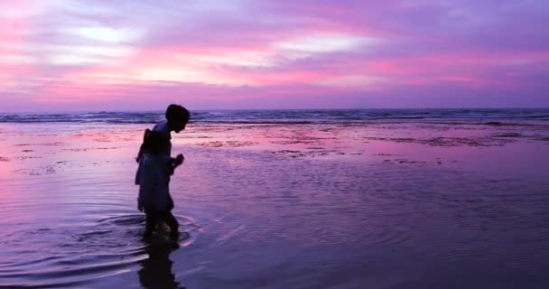 Donna e bambino che camminano sull'acqua in spiaggia — Video Stock