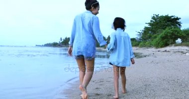  Kadın ve kızı Sahilde yürüyüş