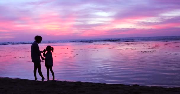 Женщина целует свою дочь на побережье — стоковое видео