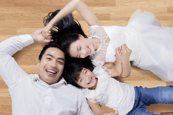 木製の床の上に横たわる魅力的な家族 — ストック写真