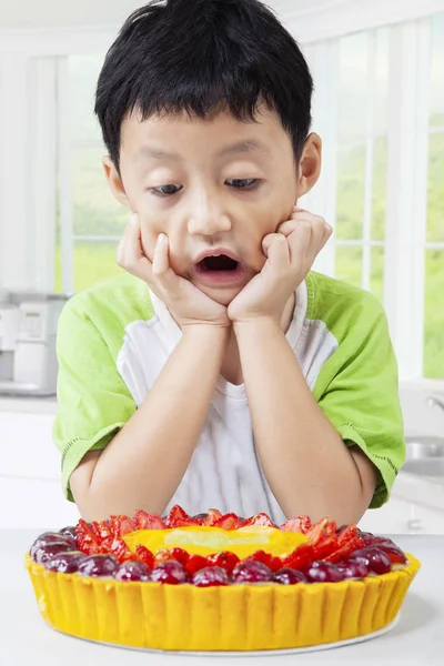 Мальчик смотрит на фруктовый пирог — стоковое фото