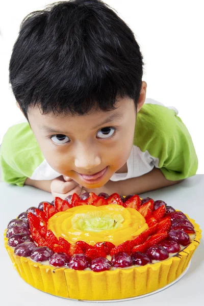 Мальчик с вкусным пирогом на столе — стоковое фото