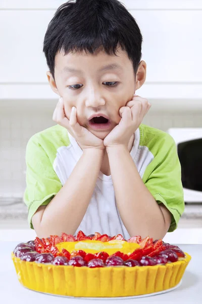 Enfant avec une tarte dans la cuisine — Photo