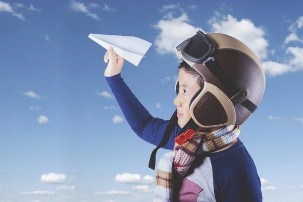 Dítě s helmu a papírové letadlo — Stock fotografie